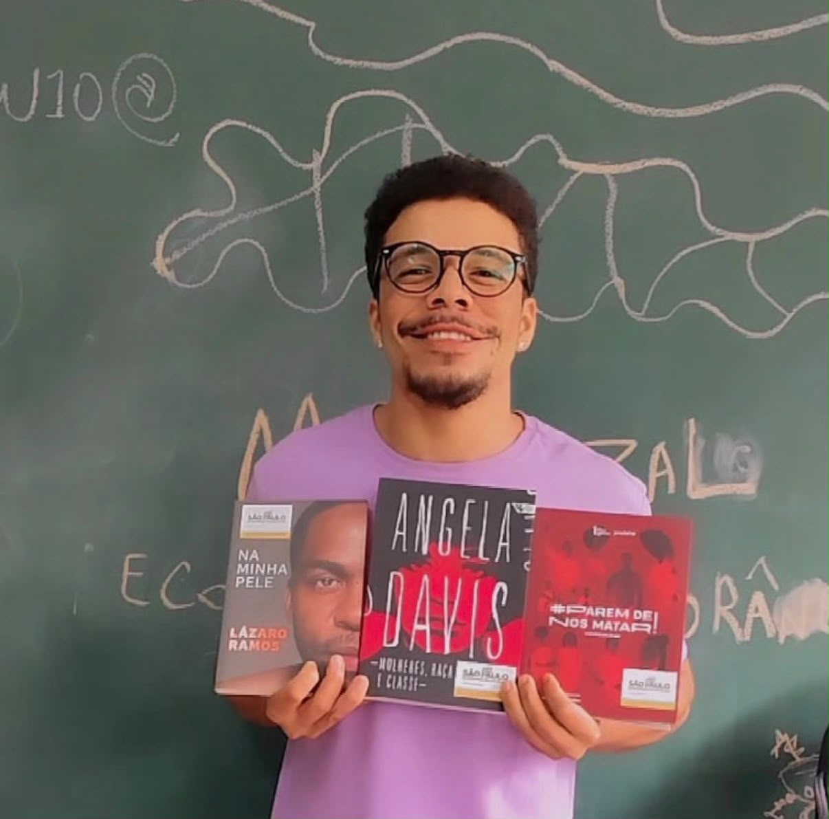 Leoncioberllem em sala de aula com livros de Lázaro Ramos, Angela Davis e literatura antirracista